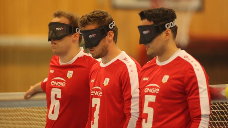 three Belgian male goalball players lined up in a row