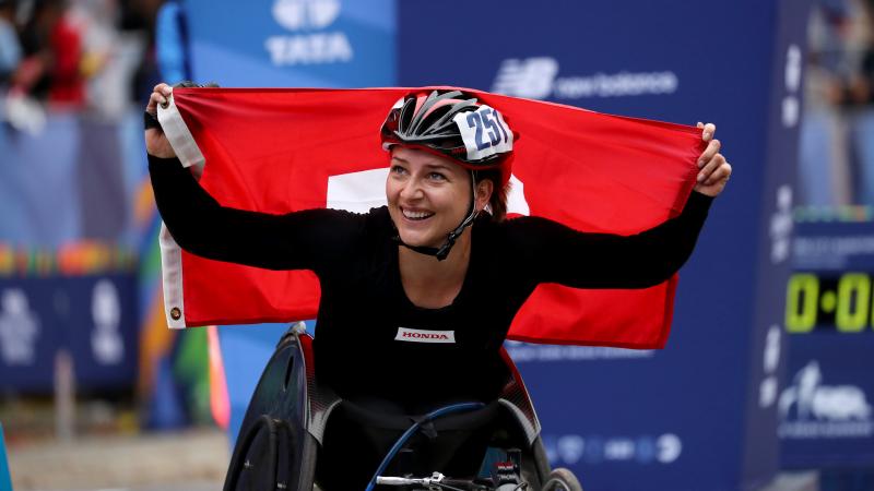 female wheelchair racer Manuela Schaer holds up the Swiss flag