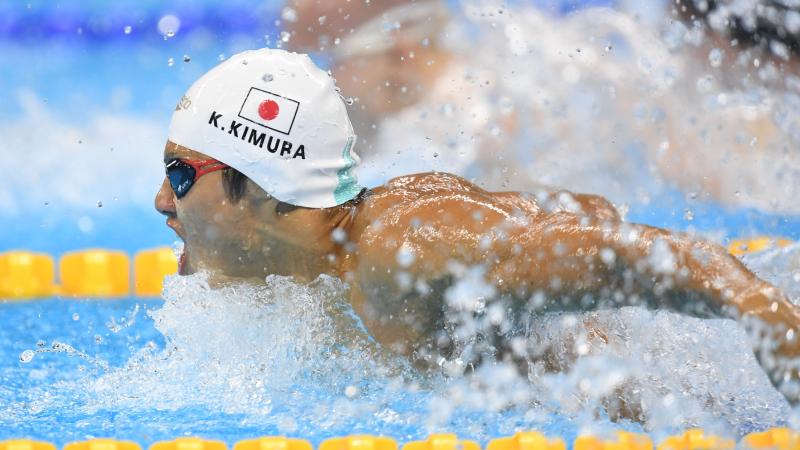 Man swimming with a cap showing the Japanese flag