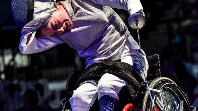 Italian female wheelchair fencer takes off her mask after a win