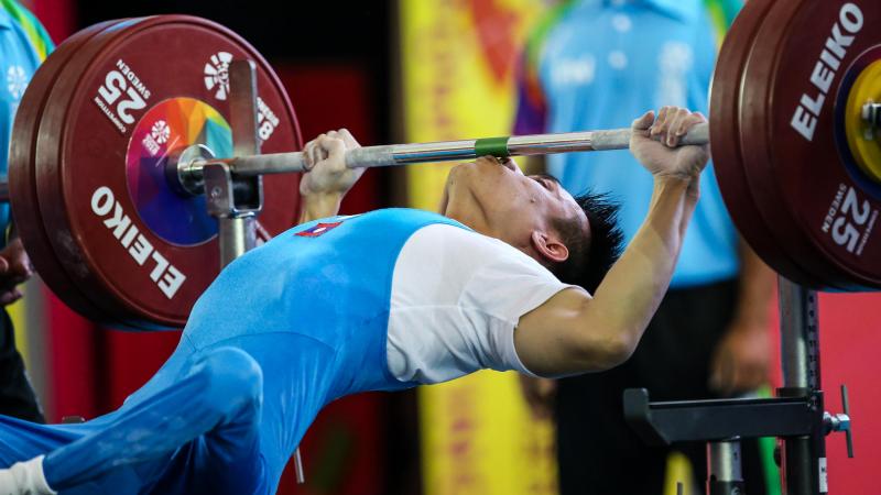 male powerlifter Pia Laophakdee kisses the bar
