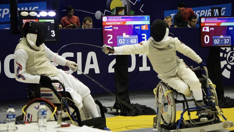two wheelchair fencers in combat