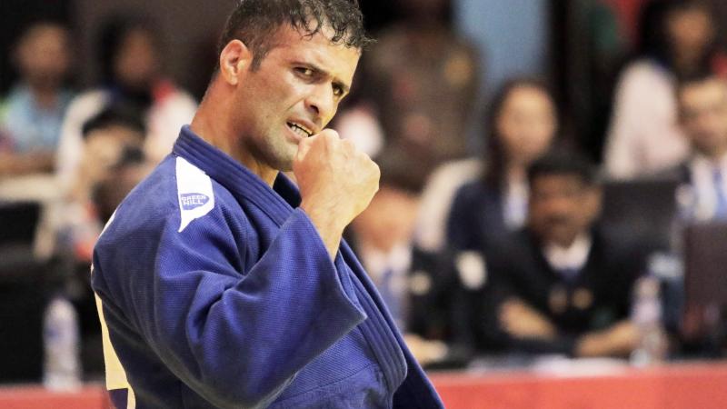 male judoka Ehsan Mousanezhad Karmozdi clenches his fist in victory
