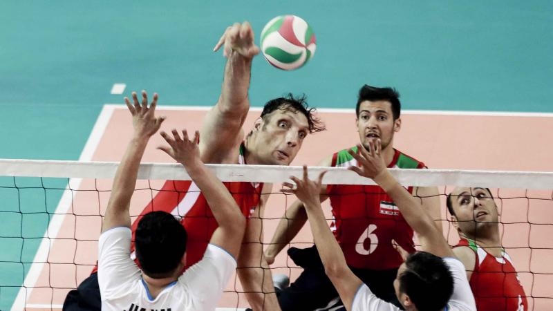 male sitting volleyball player Morteza Mehrzadselakjani blocks a ball over the net