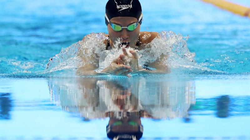 female Para swimmer Amilova Fatimakhon takes a breath during a breaststroke 