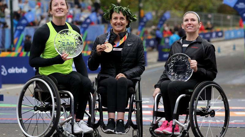 female wheelchair racers Tatyana McFadden, Manuela Schaer and Amanda McGrory holding up trophies