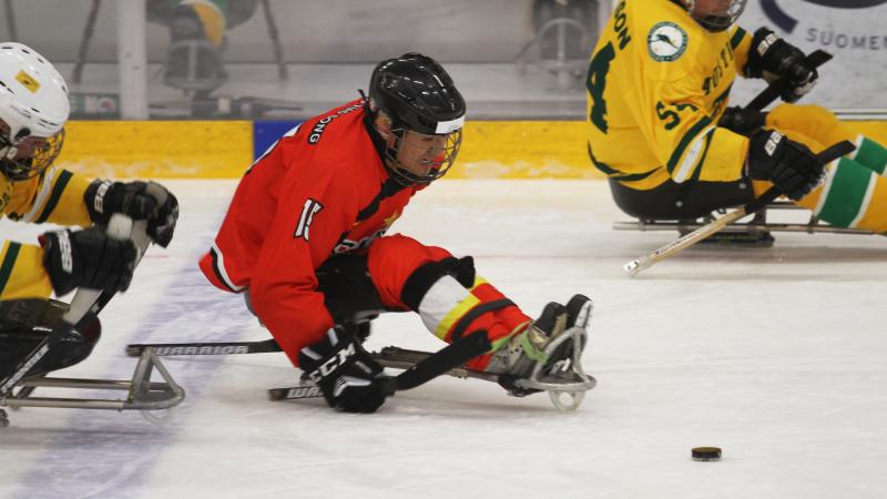 A man in a sledge playing Para ice hockey
