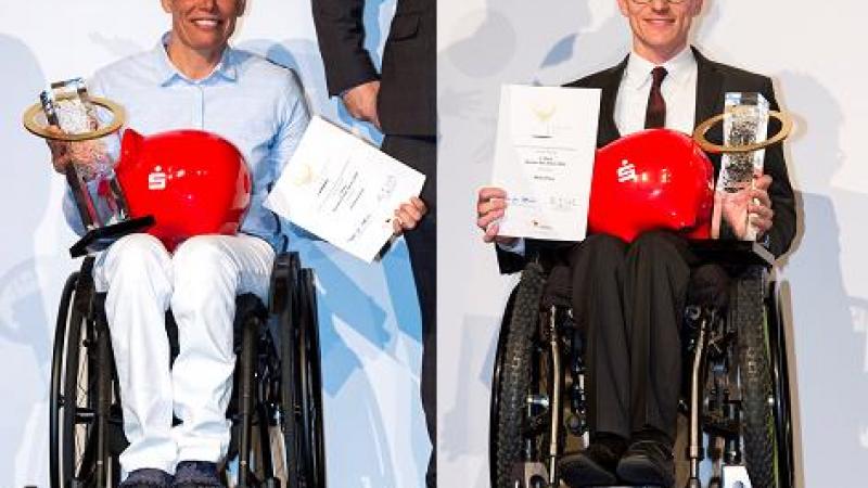 A woman and a man in wheelchairs holding a trophy and a certificate