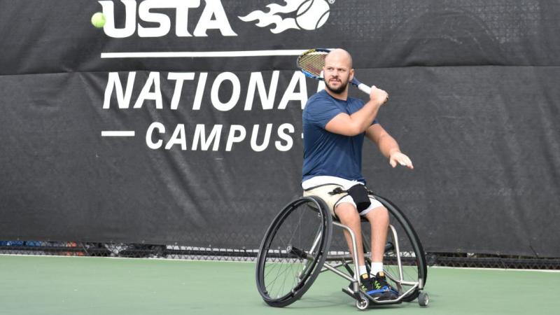 male wheelchair tennis player Stefan Olsson plays a forehand on a hard court