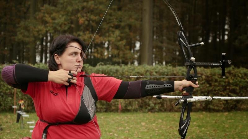 female Para archer Milena Olszewska draws back an arrow and prepares to shoot