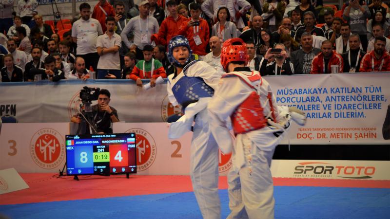 male Para taekwondo fighter Juan Garcia Lopez kicks another fighter around the back