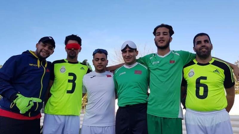 a group of five blind footballers from Oman smiling down at the camera