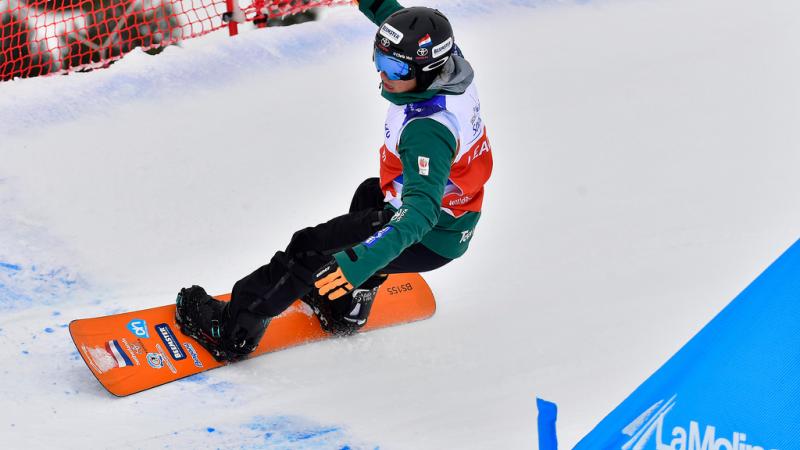 male Para snowboarder Chris Vos goes round a banked slalom bend