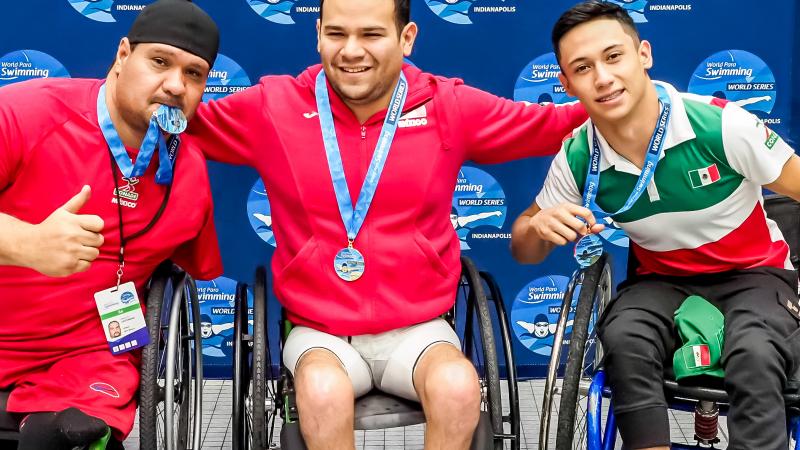 Three men in wheelchairs in a podium