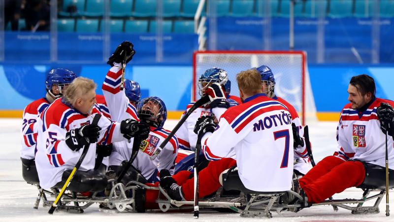 male Para ice hockey players from Czech Republic celebrating and hugging on the ice