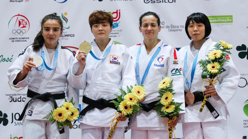 female judoka Sandrine Martinet on the podium holding her medal