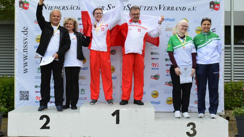 Three vision impaired shooting Para sport athletes on the podium with their guides
