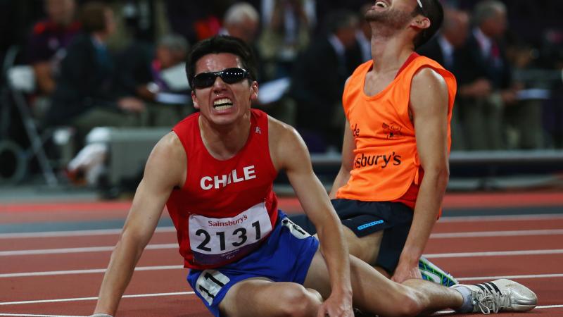 Chilean athlete and his guide on the floor exhausted after a race