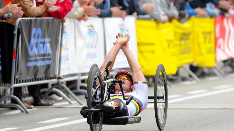 Dutch Para cyclist Jetze Plat celebrates with his hands up while crossing the finish line