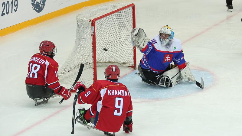 Two Russian Para ice hockey players in front the Slovakian goaltender