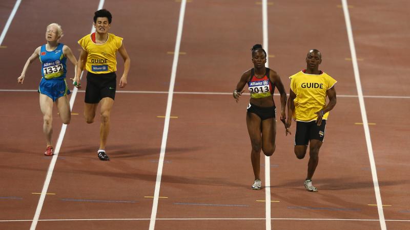 Two female vision impaired sprinters racing with their guides