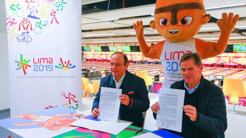 Lima 2019 President Carlos Neuhaus and Peruvian Ombudsman Walter Gutierrez holding the signed contracts