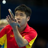 one-armed chinese table tennis player about to serve watching the ball