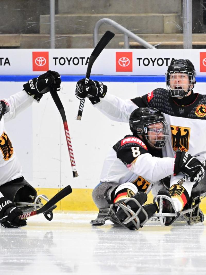Three German Para ice hockey players celebrating a goal