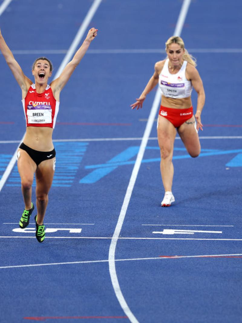 A woman crossing the line ahead of three other women in an athletics track