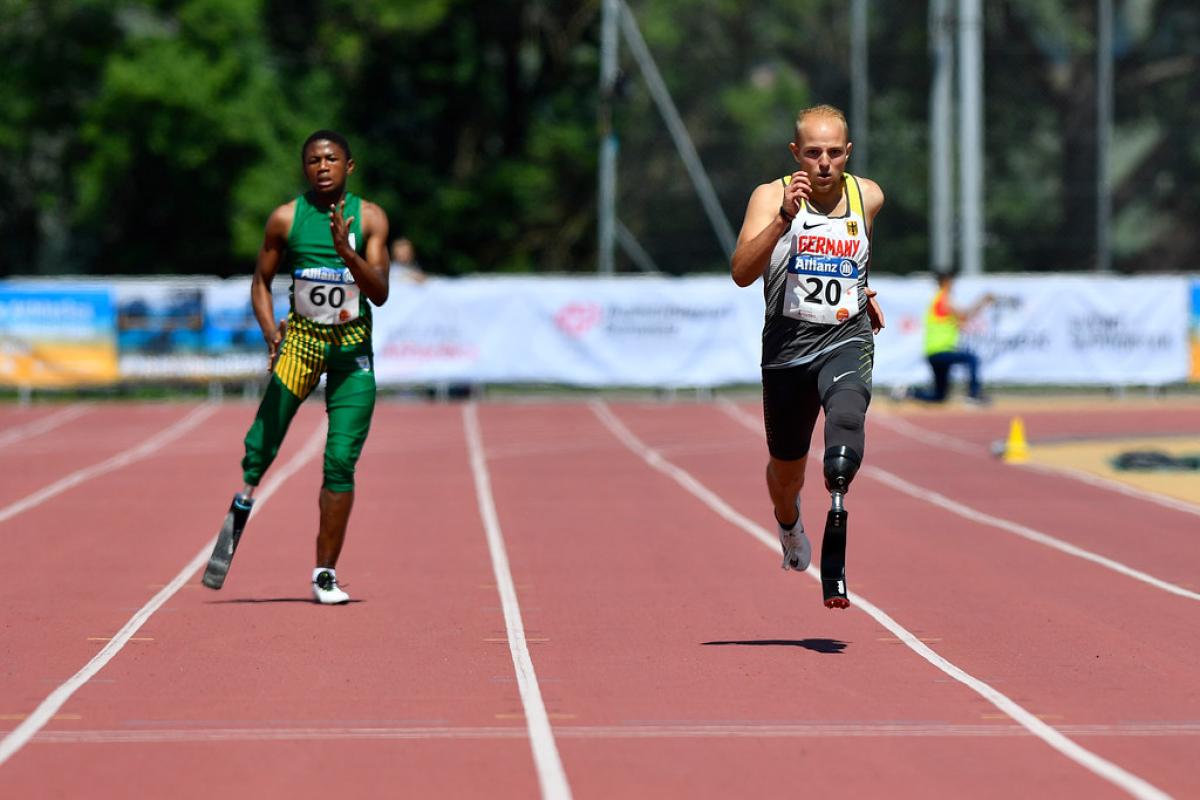 Two male sprinters with prosthesis race side by side