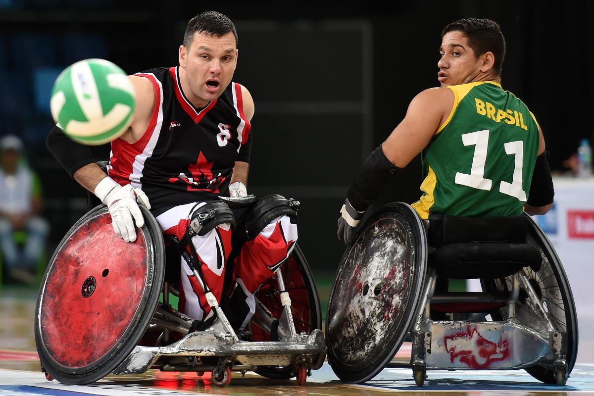 Two male opponents go for wheelchair rugby ball