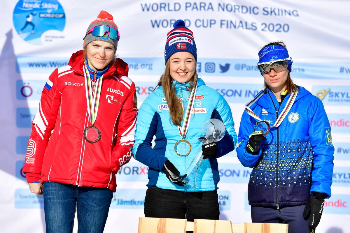 Three women in a podium with their medals