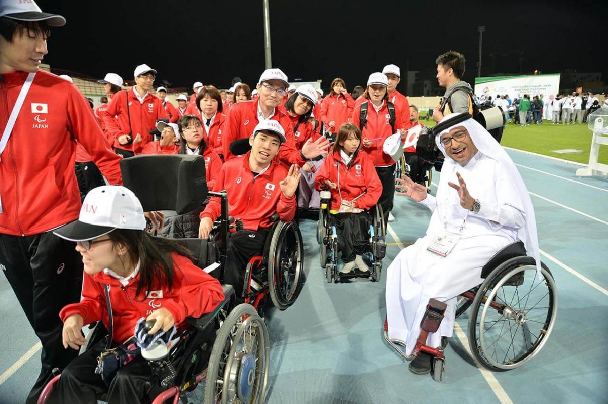 Japan delegation with man in wheelchair smiling with them