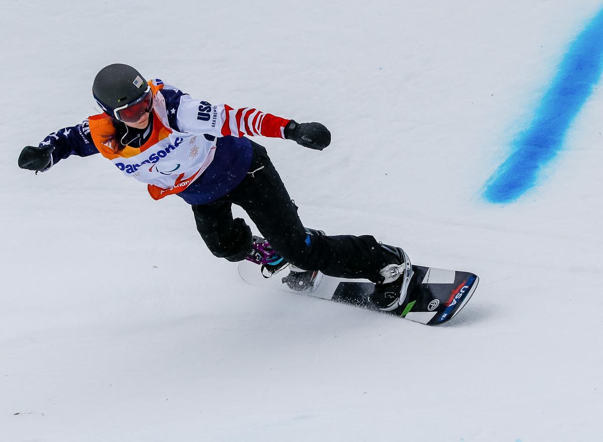 A female snowboarder with a prosthetic leg competing
