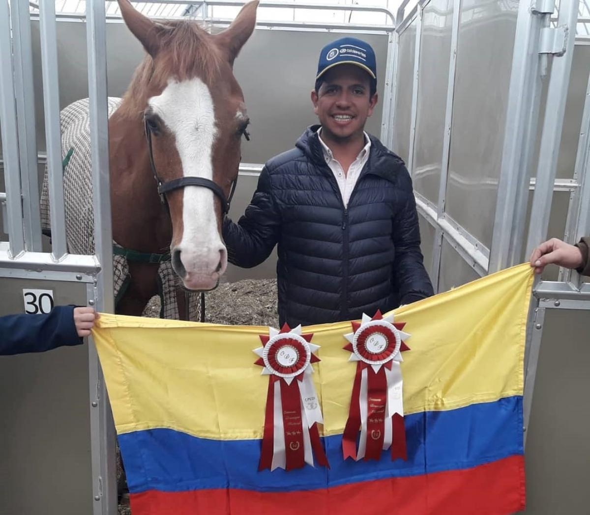 Man with his horse and a Colombian flag held in front of them