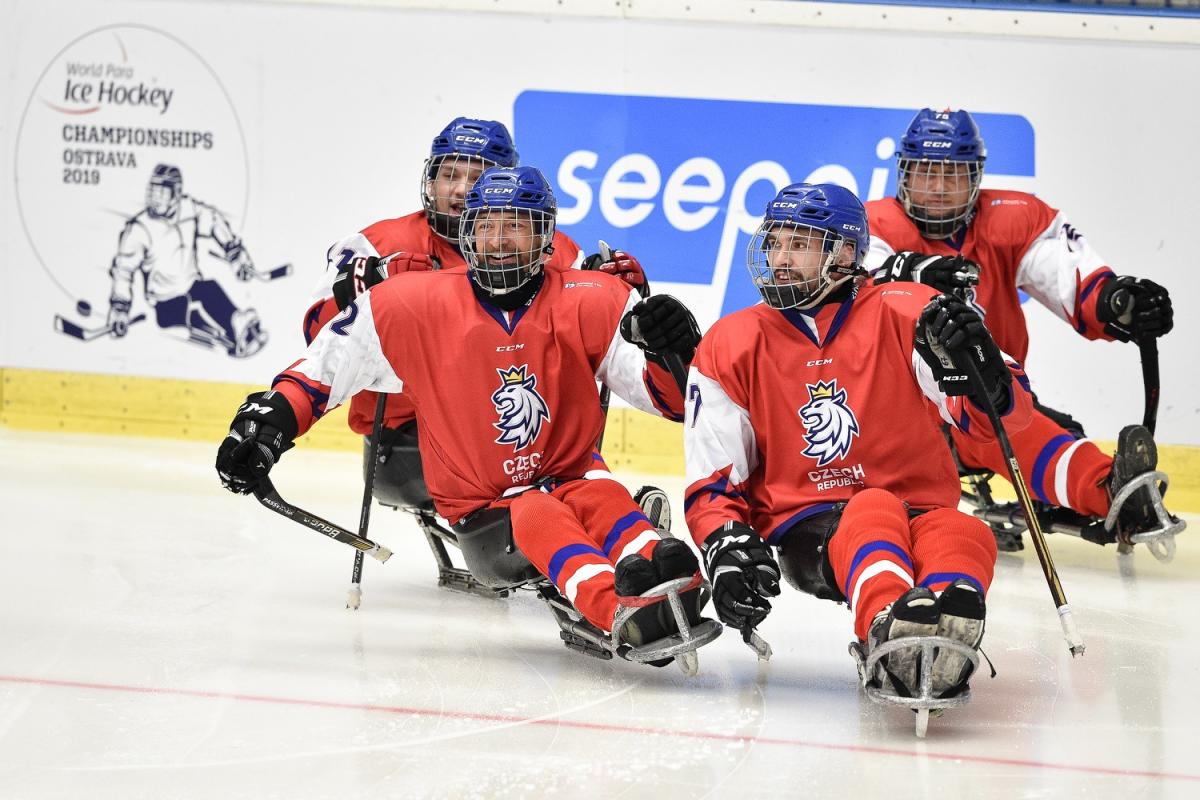 Four Czech Republic Para ice hockey players on an ice rink