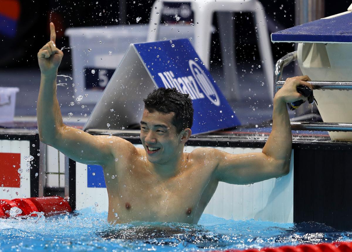 A man celebrating in a swimming pool