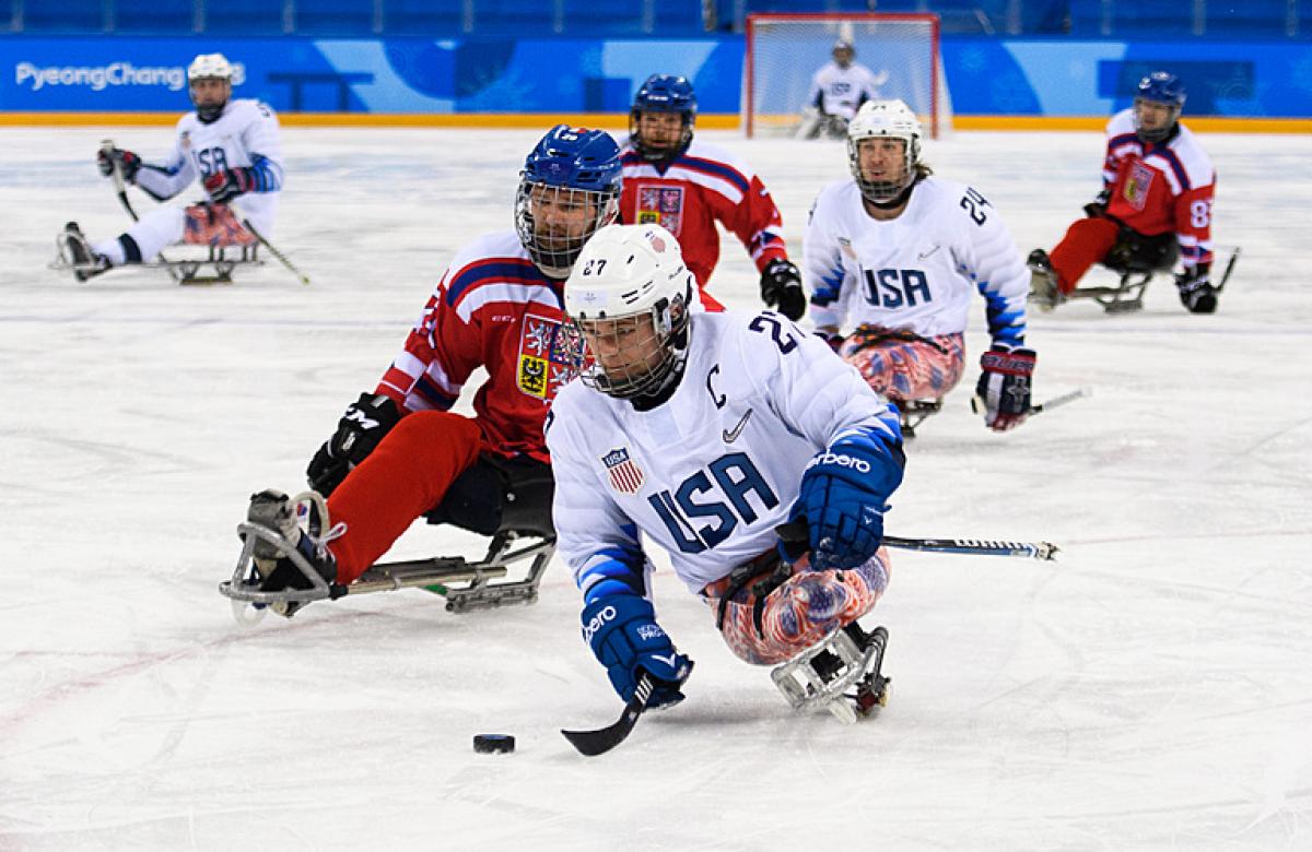 A male Para ice hockey player from Team USA in a game against Czech Republic