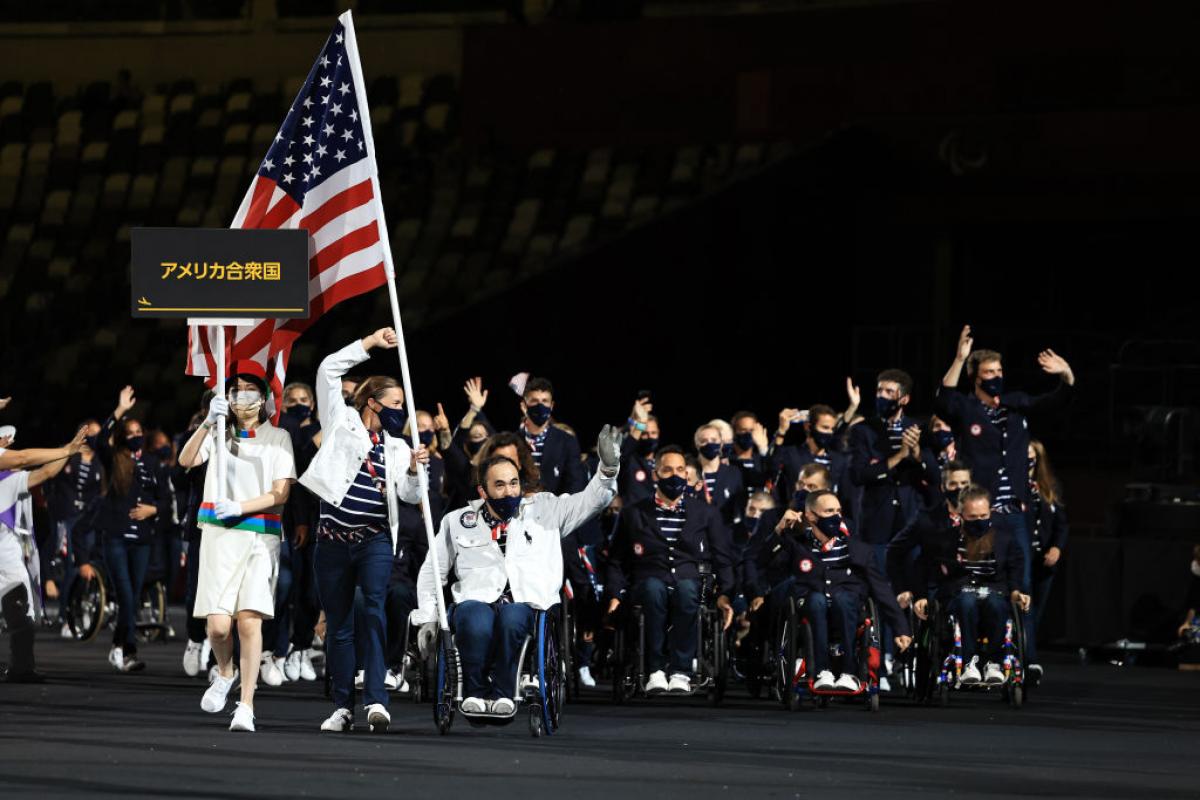The USA delegation enters the Athletes' Parade at the Opening Ceremony of the Tokyo 2020 Paralympic Games with two flagbearers in front.