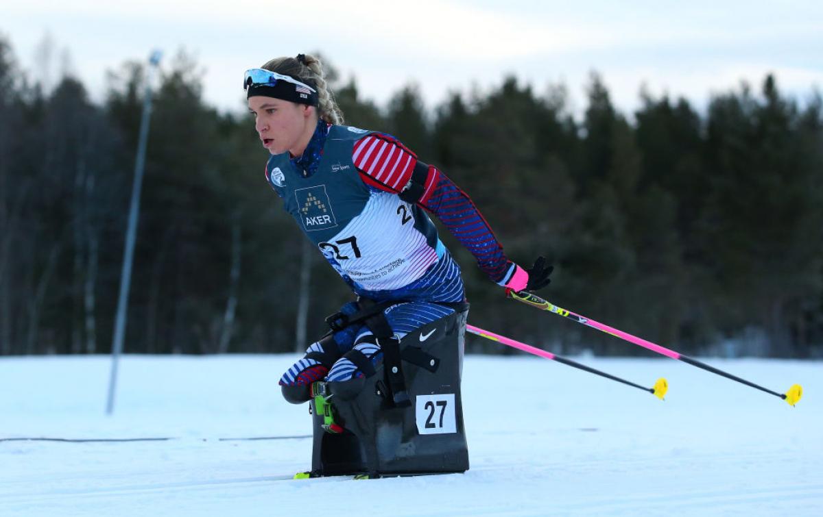 A female athlete on a sit-ski competes at the World Para Snow Sports Championships 