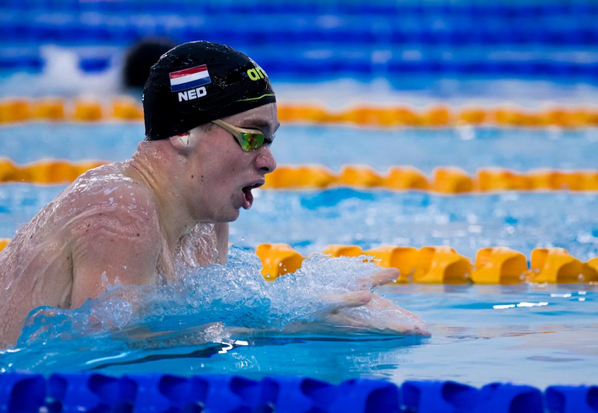 A male swimmer with a cap with the Dutch flag