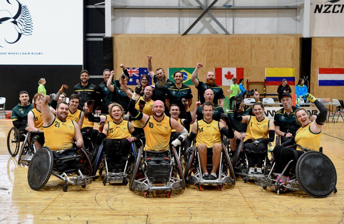 About 20 wheelchair rugby players and officials pose for a photograph