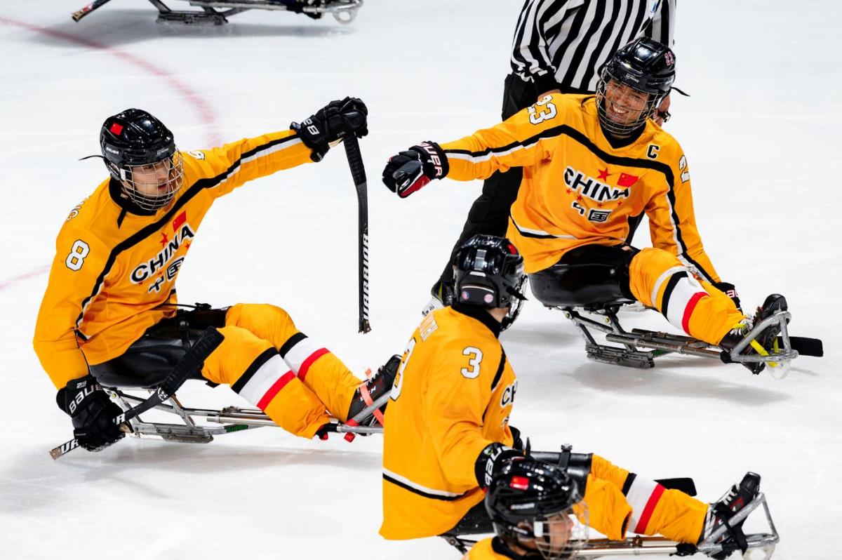 Three Chinese Para ice hockey players celebrating in a game