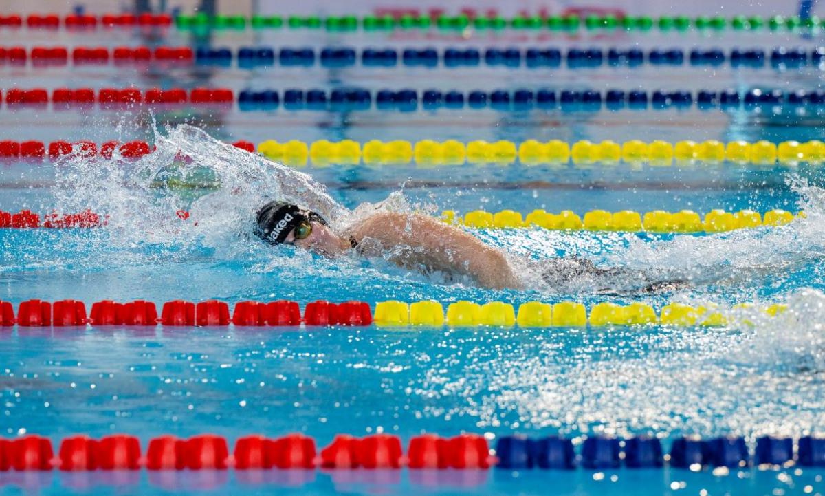 A female swimmer competing in the freestyle stroke