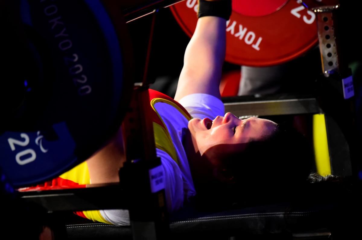 A female powerlifter raising the bar in a competition