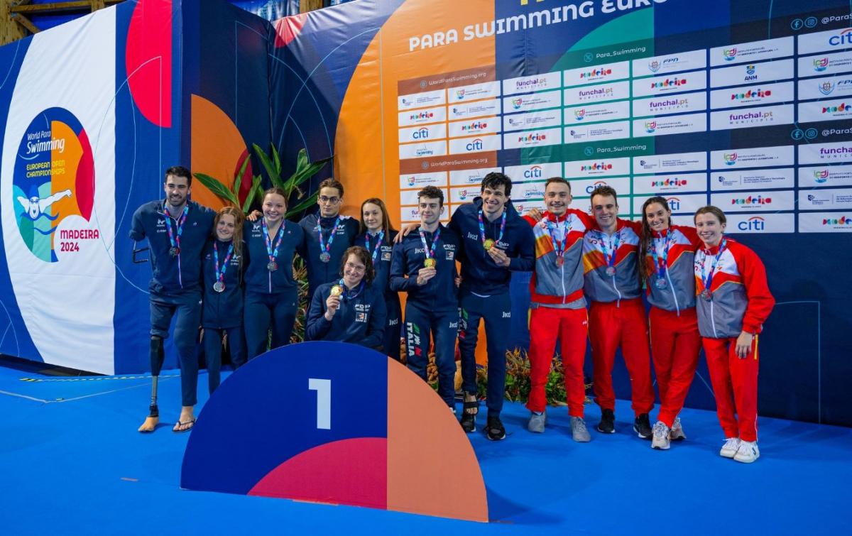 A podium of a relay swimming race with 12 athletes