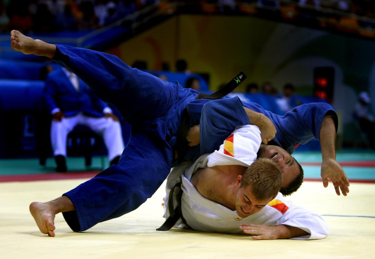 Two judo athletes fighting on the ground.
