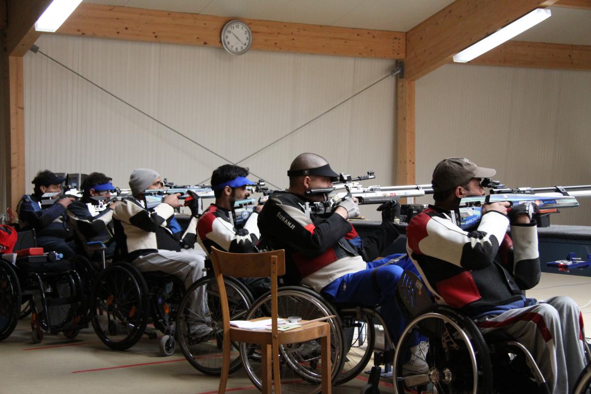 A picture of a men in a wheelchair shooting with guns
