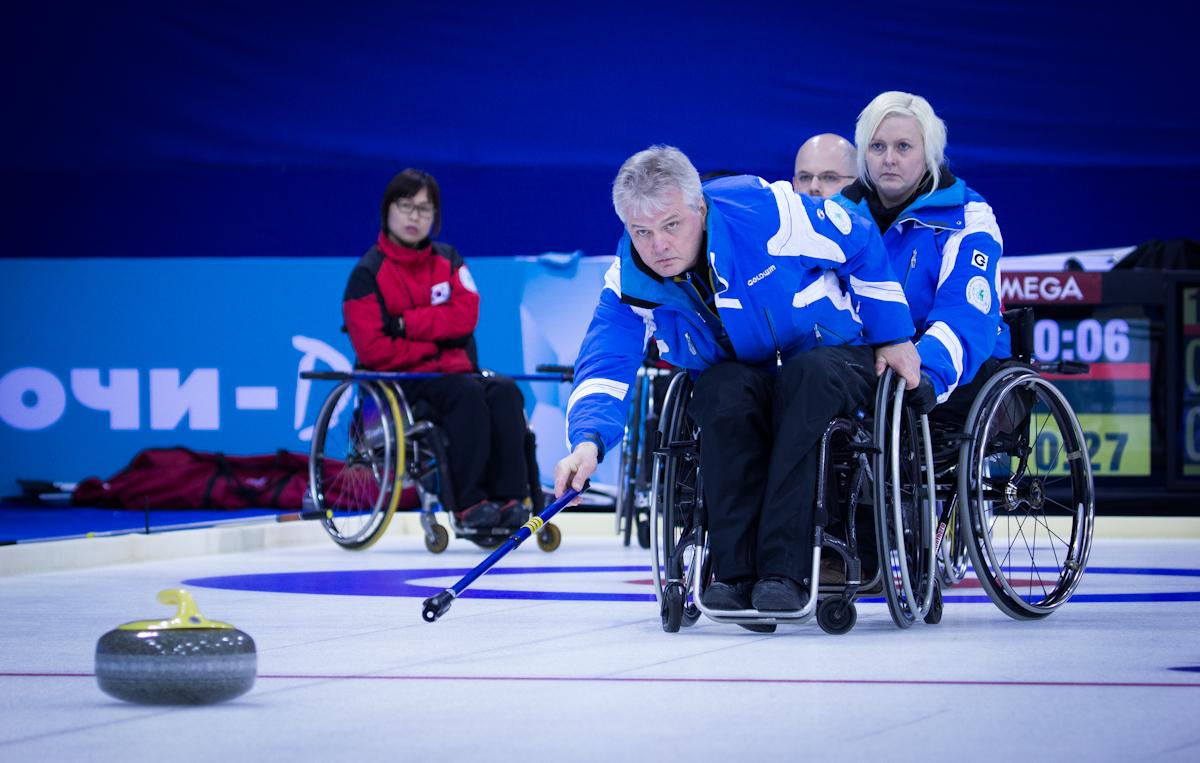A picture of a man in a wheelchair playing curling