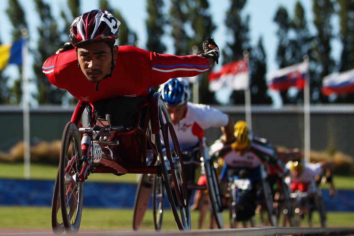 A picture of a man in a wheelchair racing on a track